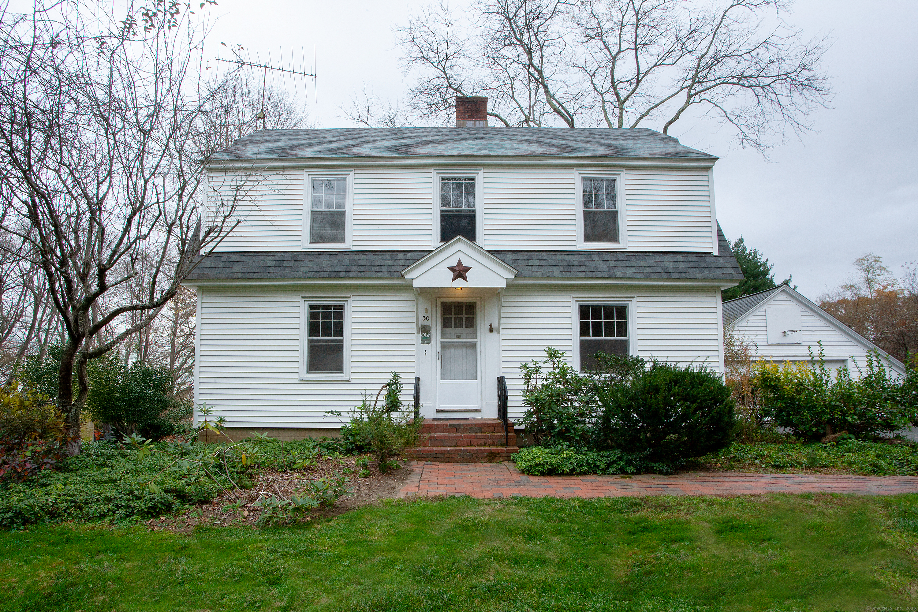 a front view of house with yard and green space