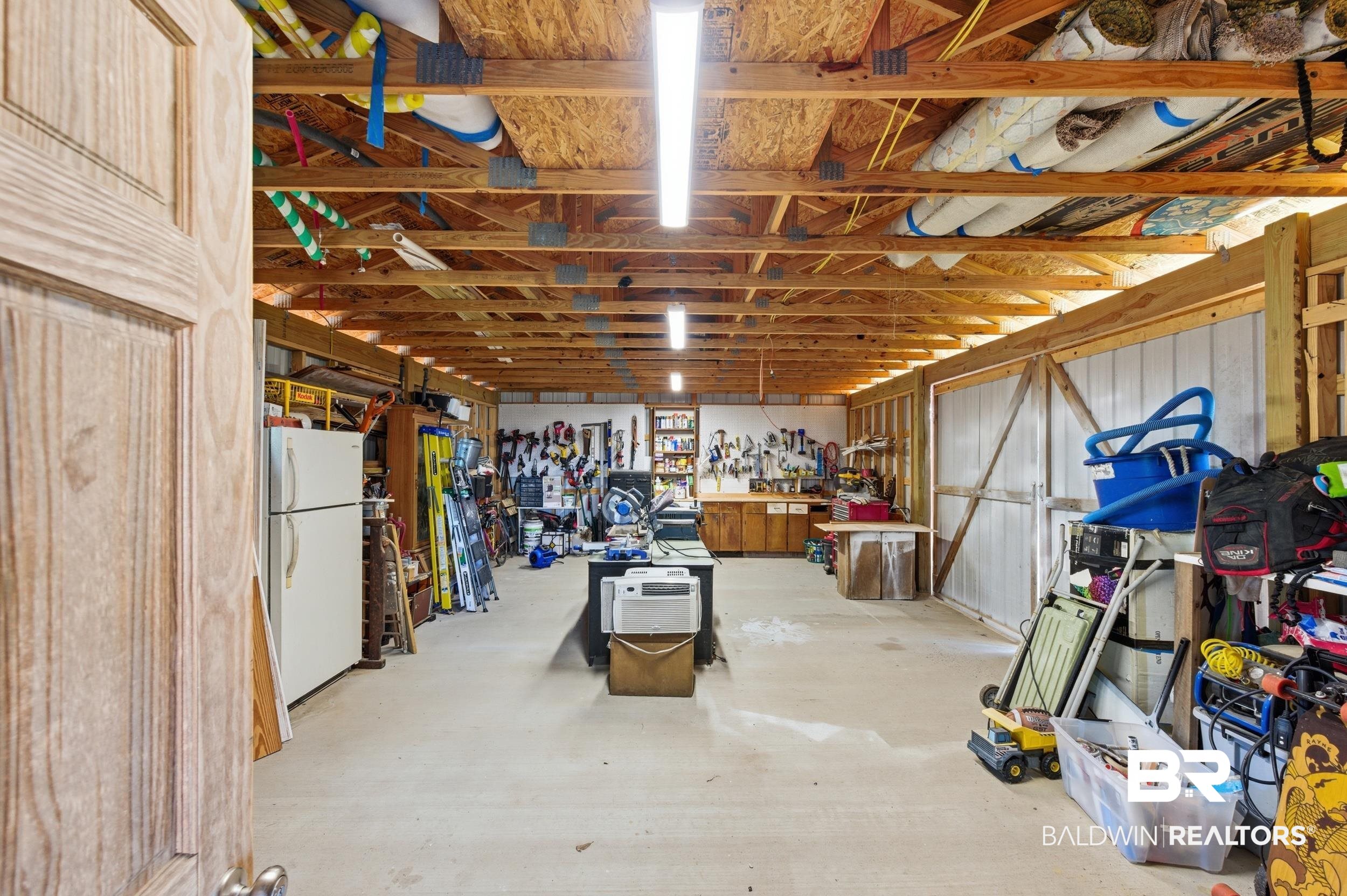 51620 Robert White Road Bay Minette, AL 36507 - Photo 68 of 81 Spacious utility building featuring exposed wood beam ceiling, concrete flooring, fluorescent lighting, and a built-in workbench