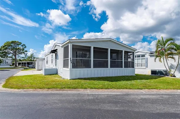 a view of a house with a yard and a large tree