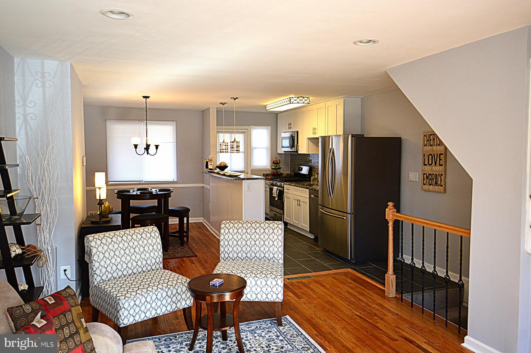 1105 Wedgewood Road Baltimore, MD 21229 - Photo 3 of 30 a kitchen with stainless steel appliances wooden floor dining table and chairs