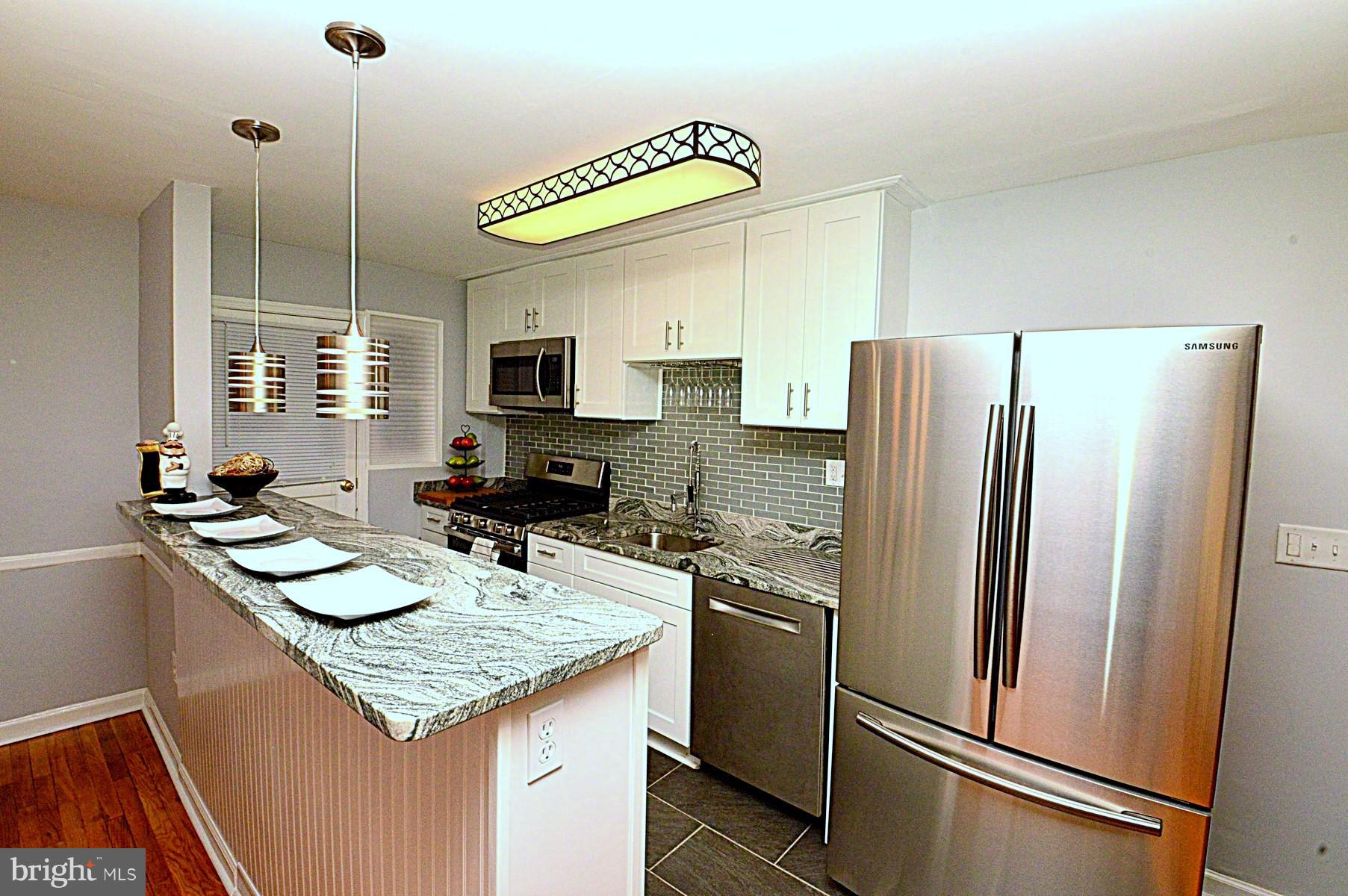 1105 Wedgewood Road Baltimore, MD 21229 - Photo 9 of 30 a kitchen with stainless steel appliances granite countertop a refrigerator a sink and a stove