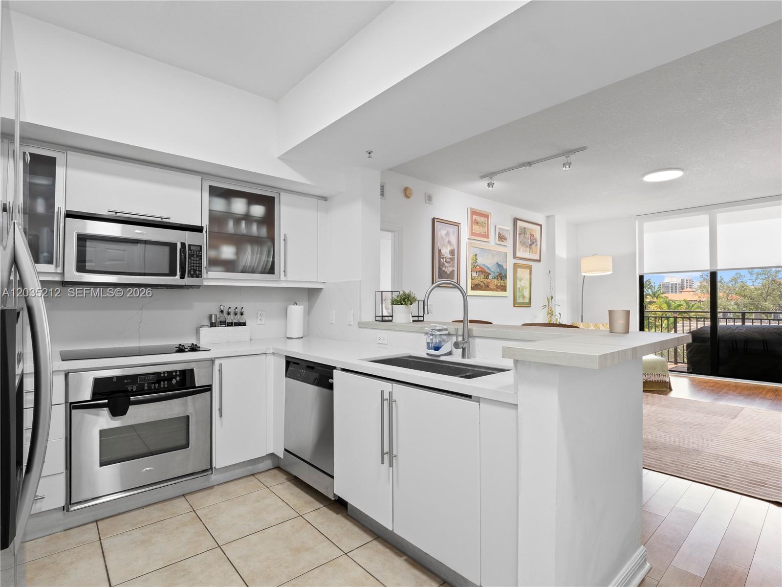 888 Douglas Road, Unit 302 Coral Gables, FL 33134 - Photo 15 of 51 KITCHEN WITH STAINLESS STEEL APPLIANCES, QUARTZ AND PORCELAIN FINISHES