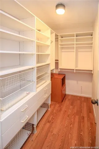 a view of a room with wooden floor and a window