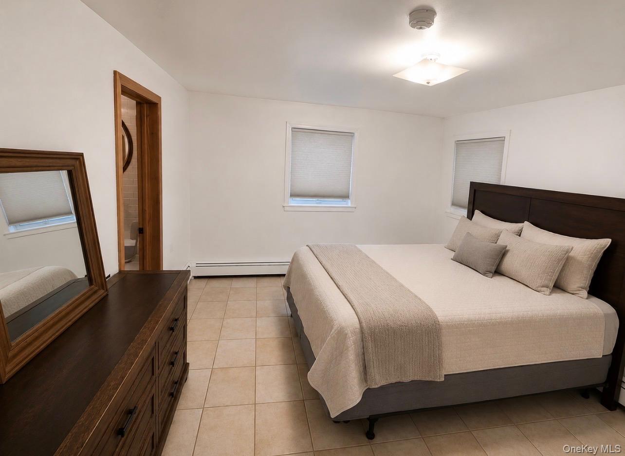 176 Spackenkill Road, Unit 1B Poughkeepsie, NY 12603 - Photo 3 of 7 a bedroom with a bed and a large mirror