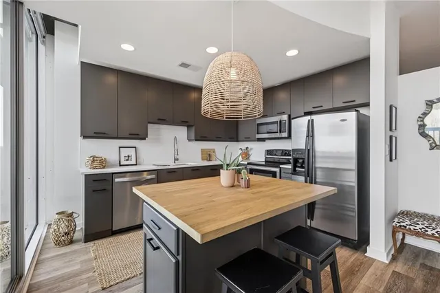 a kitchen with granite countertop a refrigerator a stove a sink dishwasher a oven with a dining table and chairs