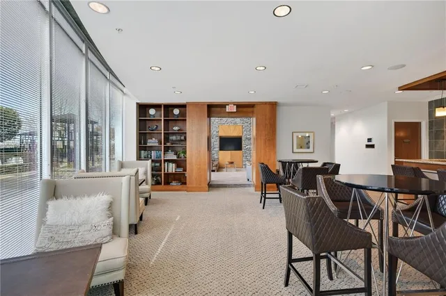 a dining hall with stainless steel appliances granite countertop a sink and a large window