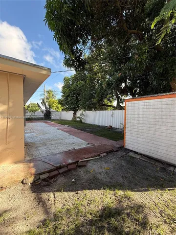 a view of a house with backyard and a tree
