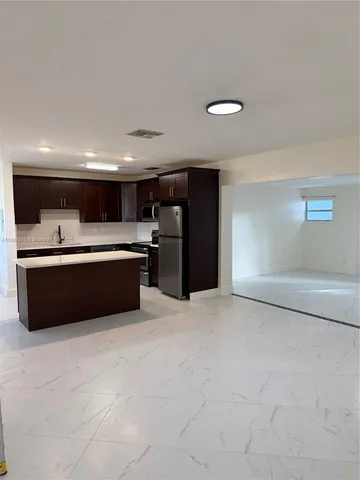 a large white kitchen with a cabinets and a sink