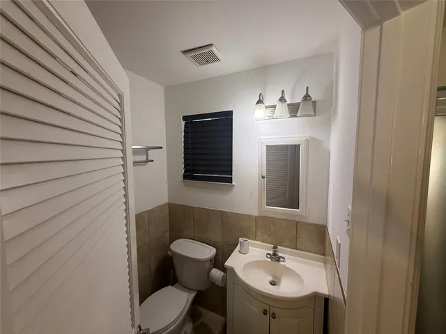 a bathroom with a sink a toilet and mirror