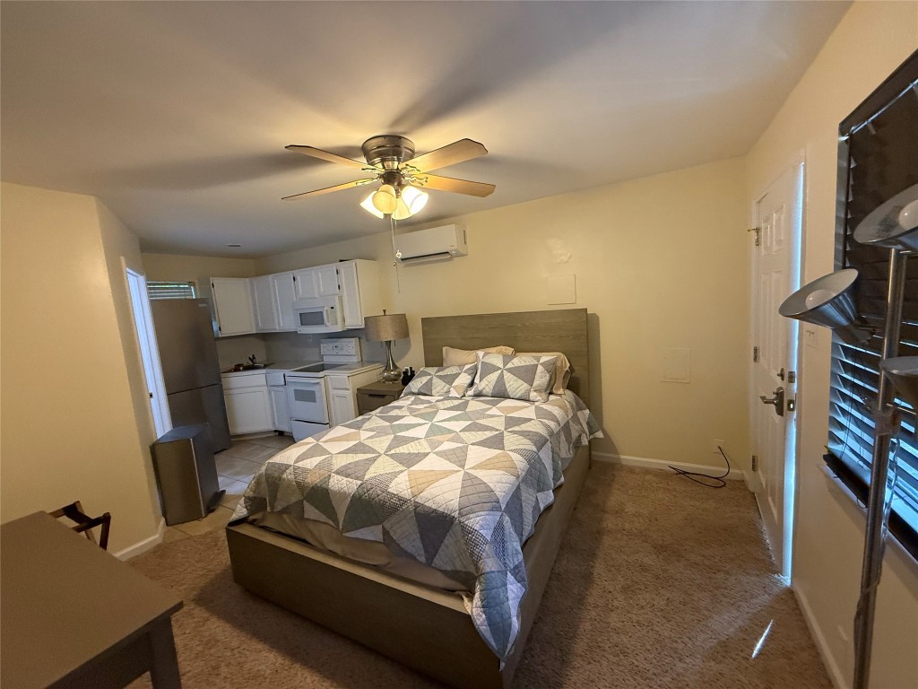 4413 Nixon Lane, Unit C Austin, TX 78725 - Photo 5 of 9 a bedroom with a bed and a flat screen tv