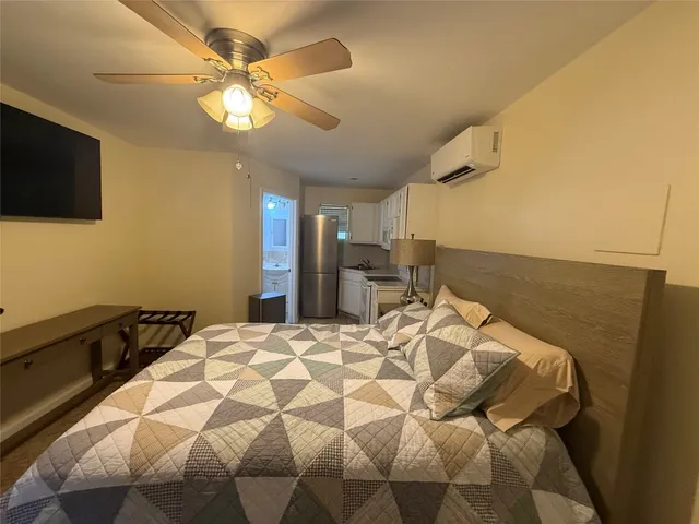 a bed sitting in a bedroom and tv on dresser