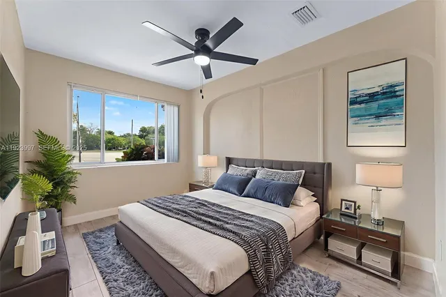 a bedroom with a large bed a chandelier and a window