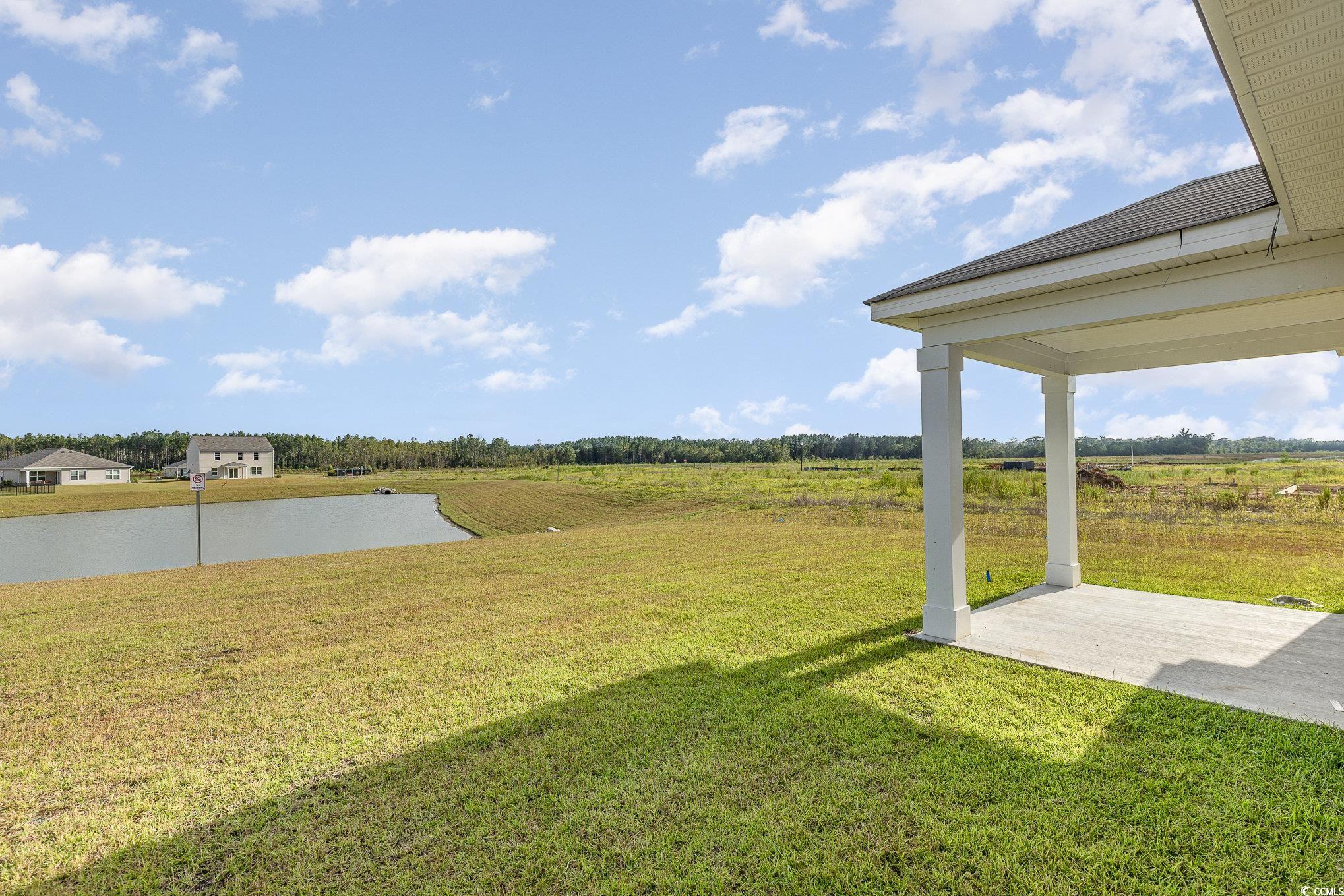 7382 Meadow Walk Loop Loris, SC 29569 - Photo 20 of 24 View of green lawn featuring a water view, a patio area, and a view of countryside