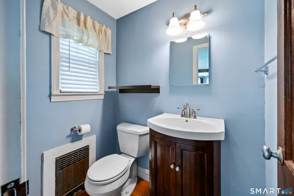 a bathroom with a toilet sink and mirror