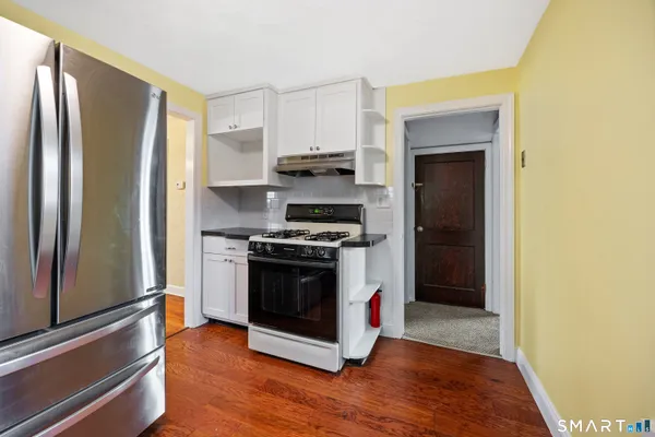 a kitchen with stainless steel appliances granite countertop a refrigerator and a stove
