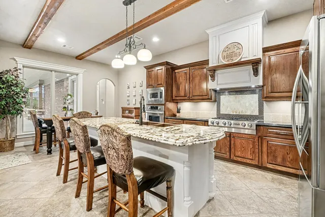 a kitchen with stainless steel appliances granite countertop a stove refrigerator sink and cabinets