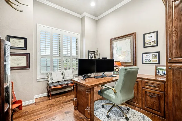 a view of a workspace with furniture and a window