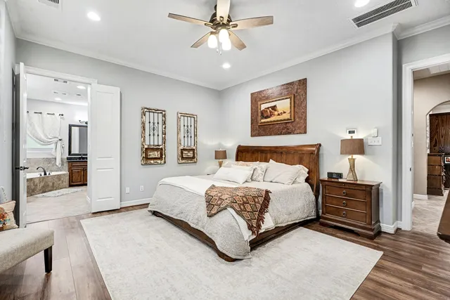 a spacious bedroom with a bed and a chandelier