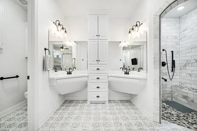 a bathroom with a double vanity sink mirror and shower