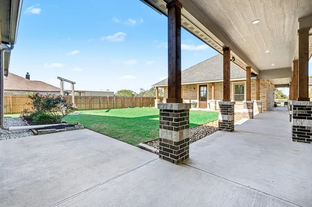 a view of a patio with chairs and table with wooden fence