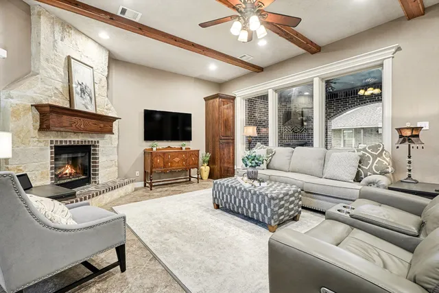 a living room with furniture a fireplace and a flat screen tv