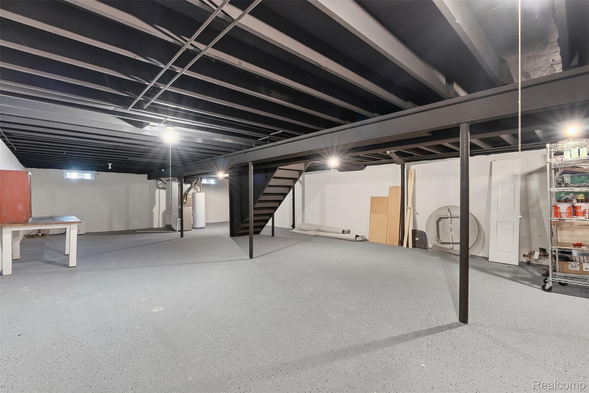 1750 Henbert Road West Bloomfield, MI 48324 - Photo 26 of 32 Expansive unfinished basement featuring painted structural beams, concrete flooring, and an exposed ceiling