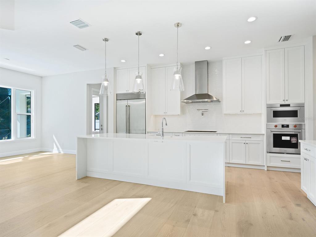 1876 Magnolia Street Sarasota, FL 34239 - Photo 11 of 72 a large white kitchen with kitchen island white cabinets and stainless steel appliances