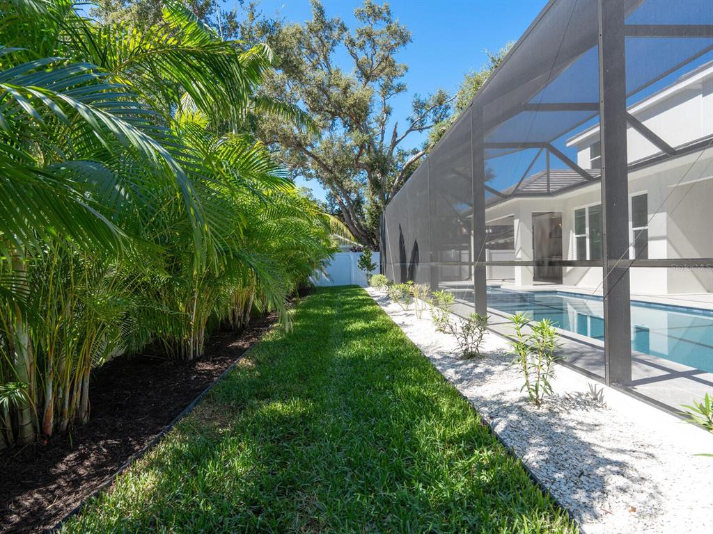 1876 Magnolia Street Sarasota, FL 34239 - Photo 48 of 72 a view of a yard in front of a brick house with plants and large tree