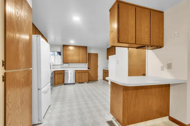 a view of a kitchen with a sink and a refrigerator