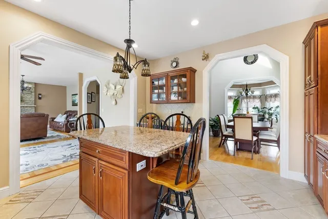 a dining hall with stainless steel appliances granite countertop a table and chairs