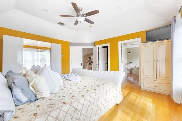 a spacious bedroom with a large bed and a chandelier