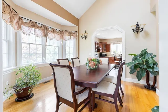 a dining room with furniture potted plants and wooden floor