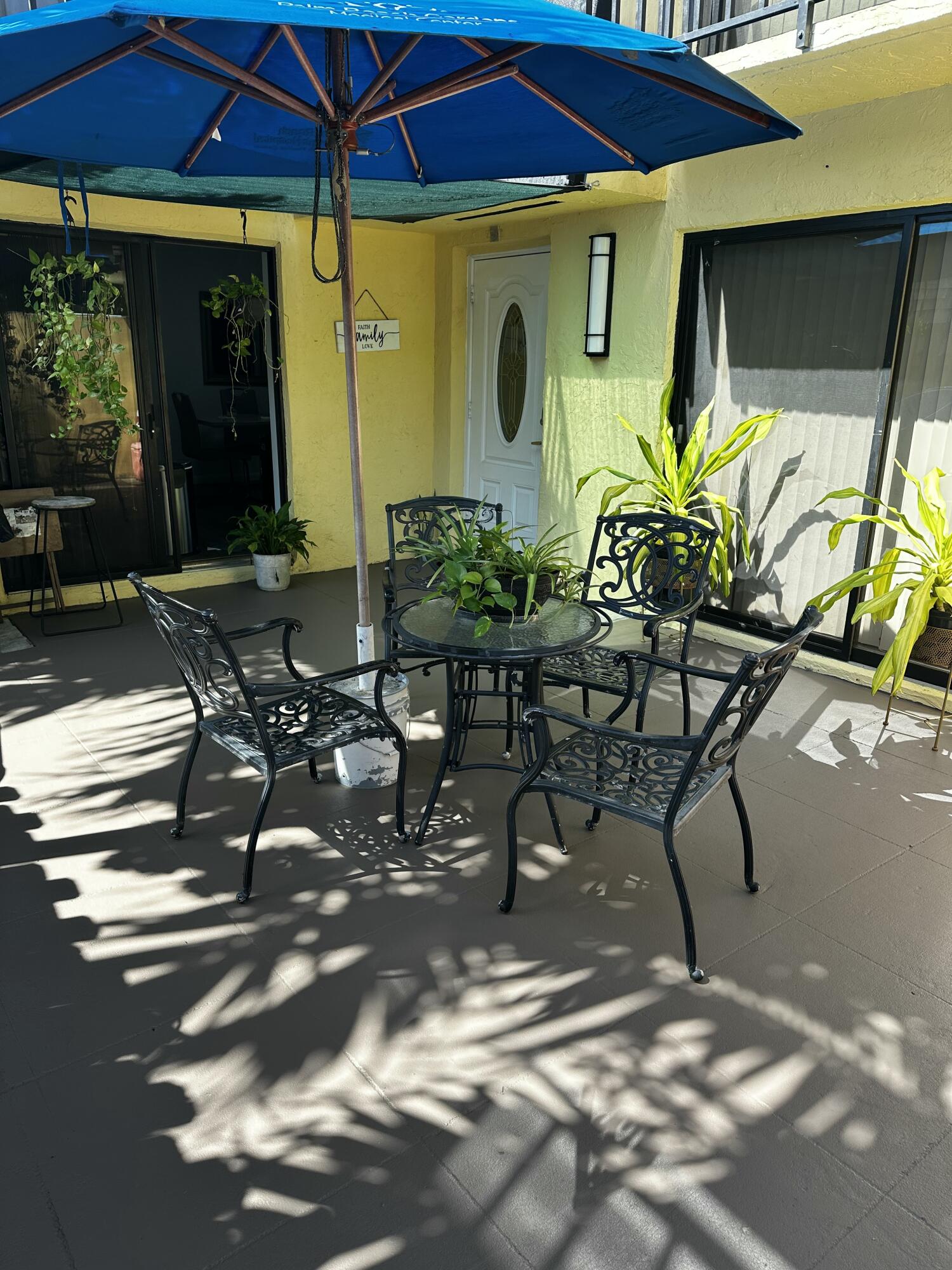 218 Woodland Road Palm Springs, FL 33461 - Photo 44 of 45 a view of a patio with table and chairs potted plants