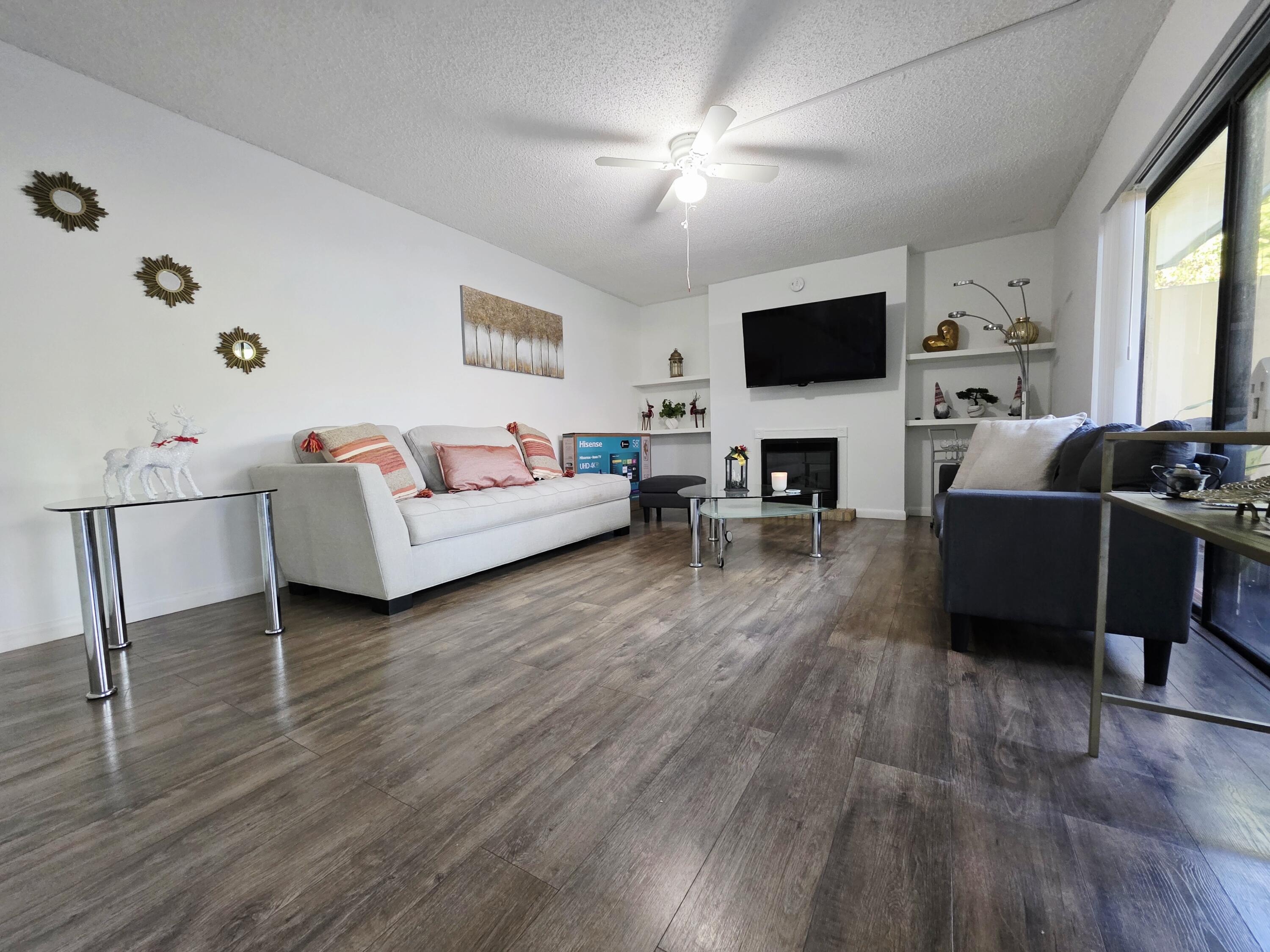 218 Woodland Road Palm Springs, FL 33461 - Photo 6 of 45 a living room with furniture a flat screen tv and a fireplace