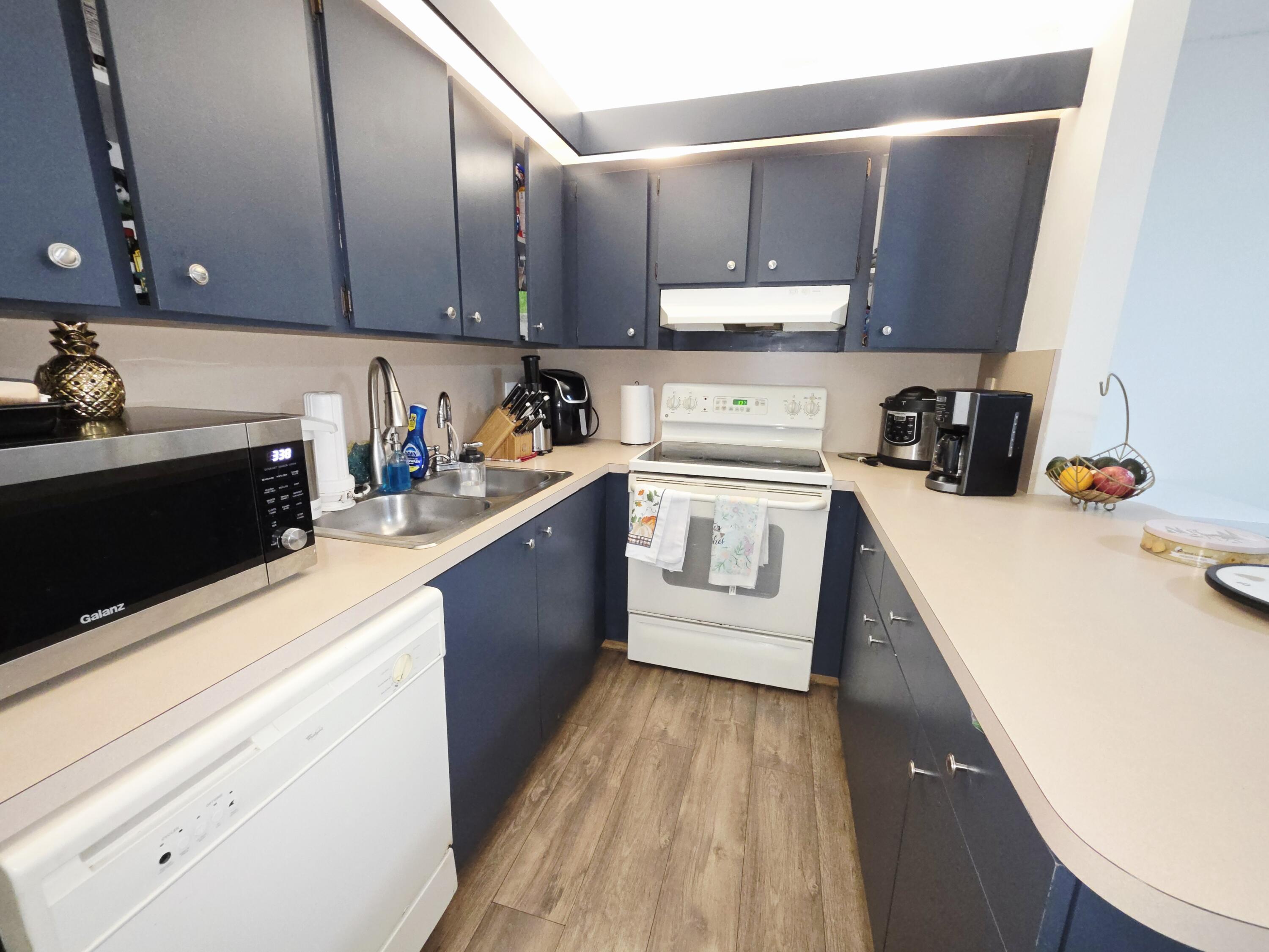 218 Woodland Road Palm Springs, FL 33461 - Photo 10 of 45 a kitchen with wooden cabinets and sink
