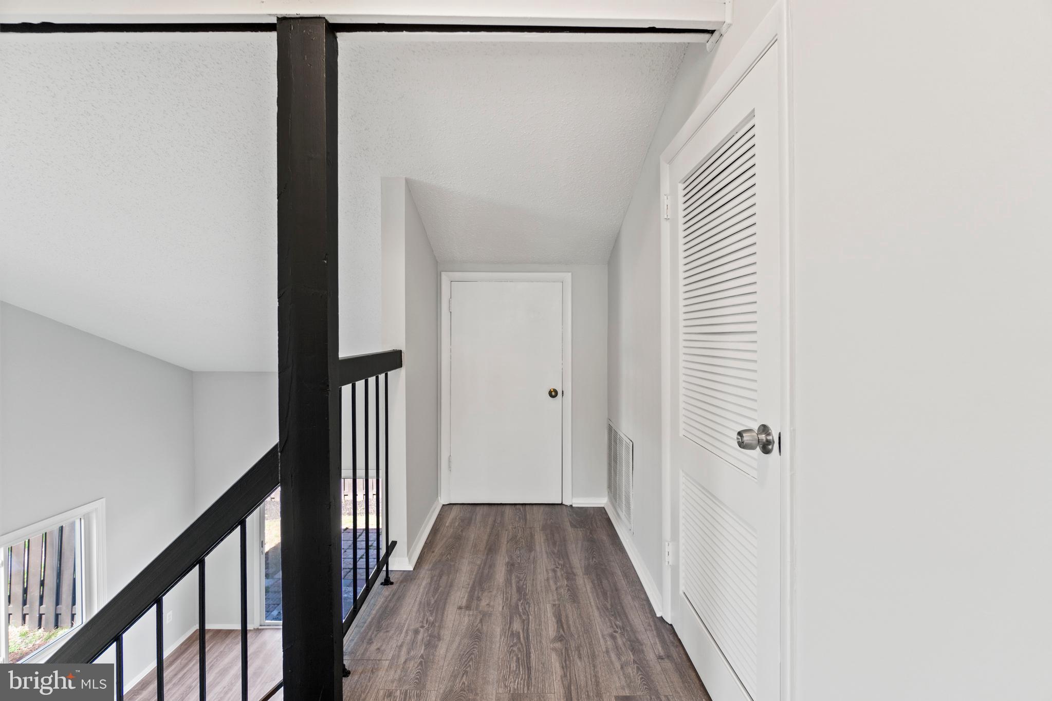 2 Regis Circle Sterling, VA 20164 - Photo 14 of 20 a view of a hallway with wooden floor and staircase