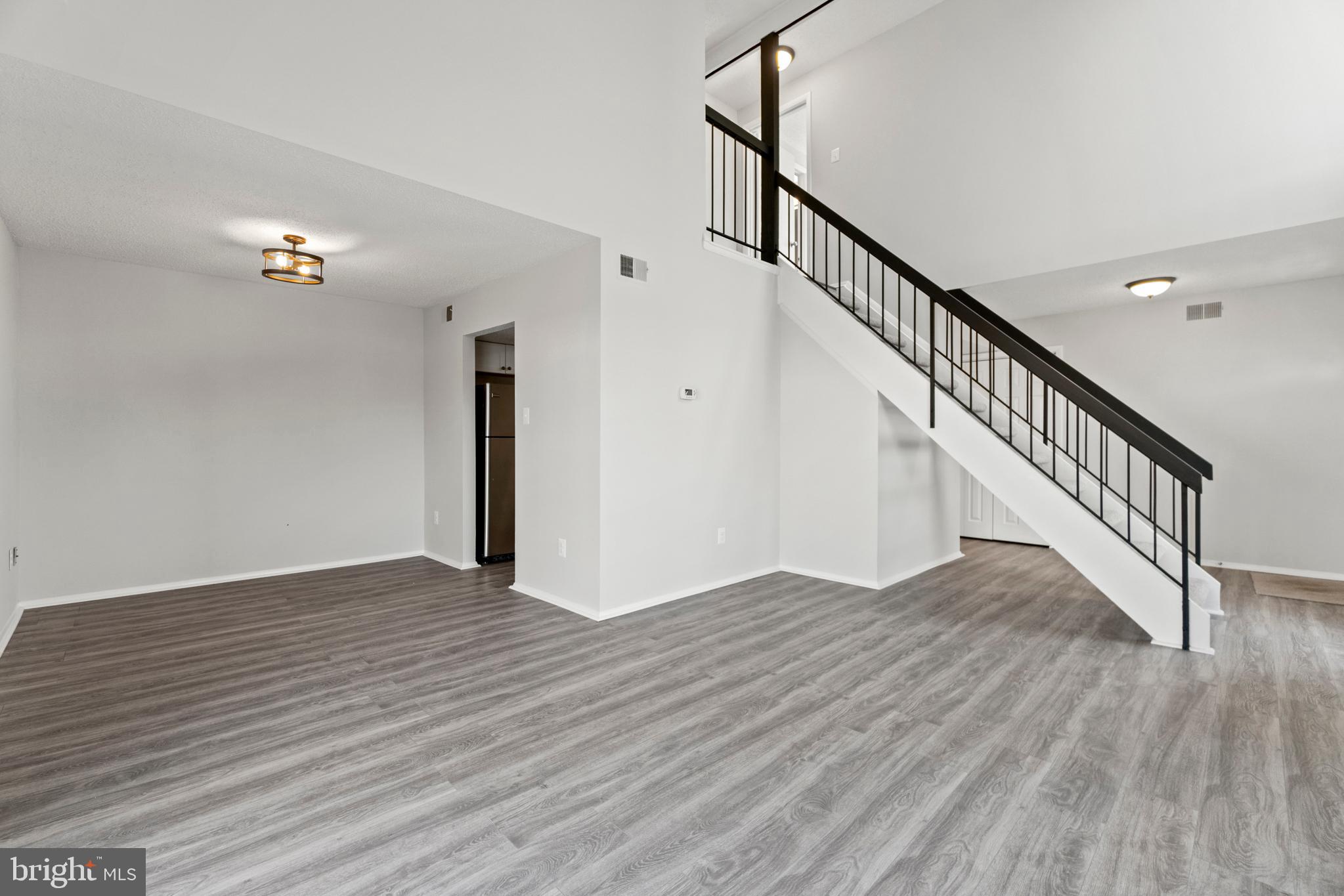 2 Regis Circle Sterling, VA 20164 - Photo 4 of 20 a view of an empty room with wooden floor and stairs