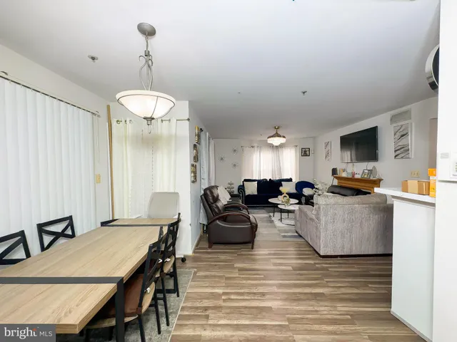 a living room with furniture kitchen view and a chandelier