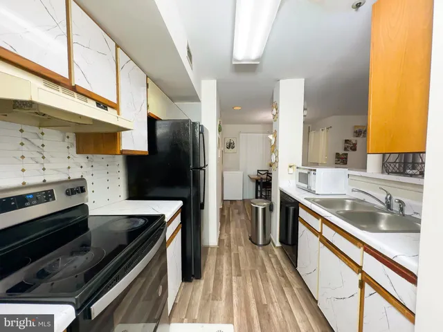 a kitchen with stainless steel appliances a stove a sink and a refrigerator