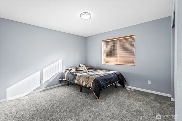 a bed sitting in a bedroom next to a window