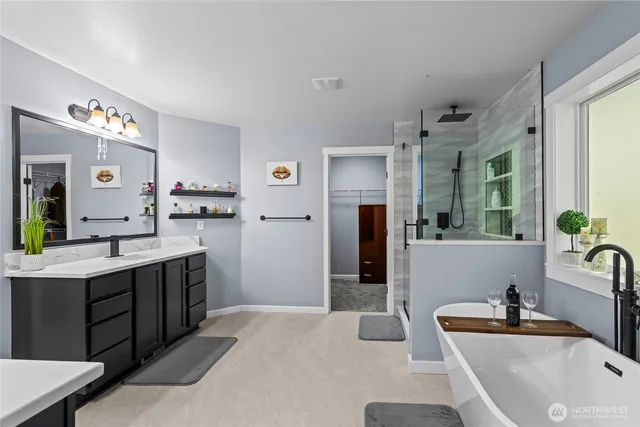 a spacious bathroom with a tub sink and mirror