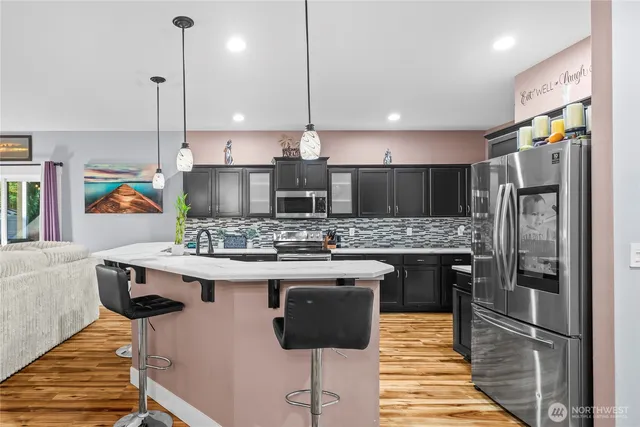 a kitchen with stainless steel appliances granite countertop a sink a stove and a refrigerator