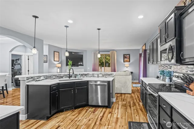 a kitchen with stainless steel appliances granite countertop a stove and a sink