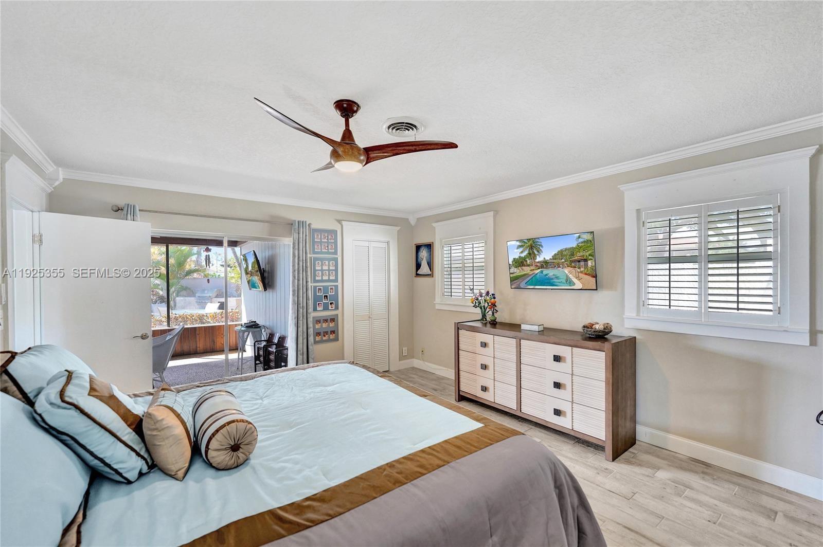 4060 Northeast 26th Avenue Lighthouse Point, FL 33064 - Photo 14 of 34 a bedroom with a bed and a chandelier