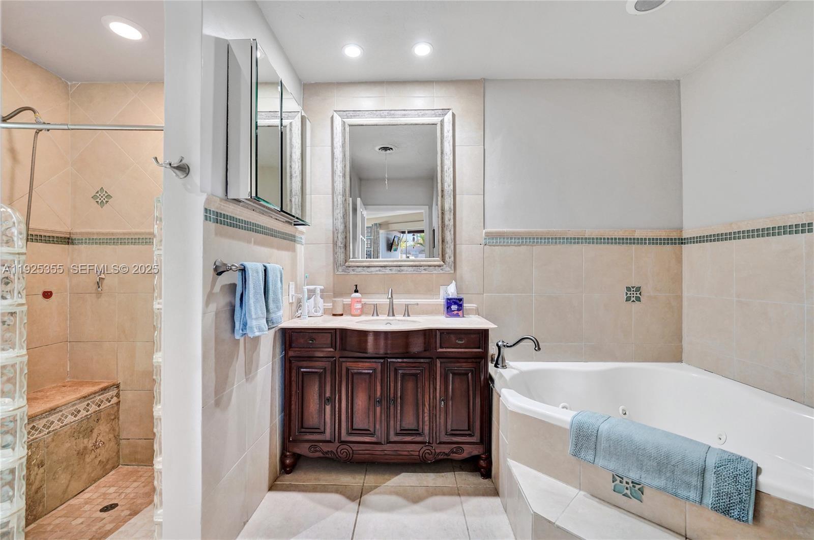 4060 Northeast 26th Avenue Lighthouse Point, FL 33064 - Photo 15 of 34 a bathroom with a bathtub a sink and a mirror