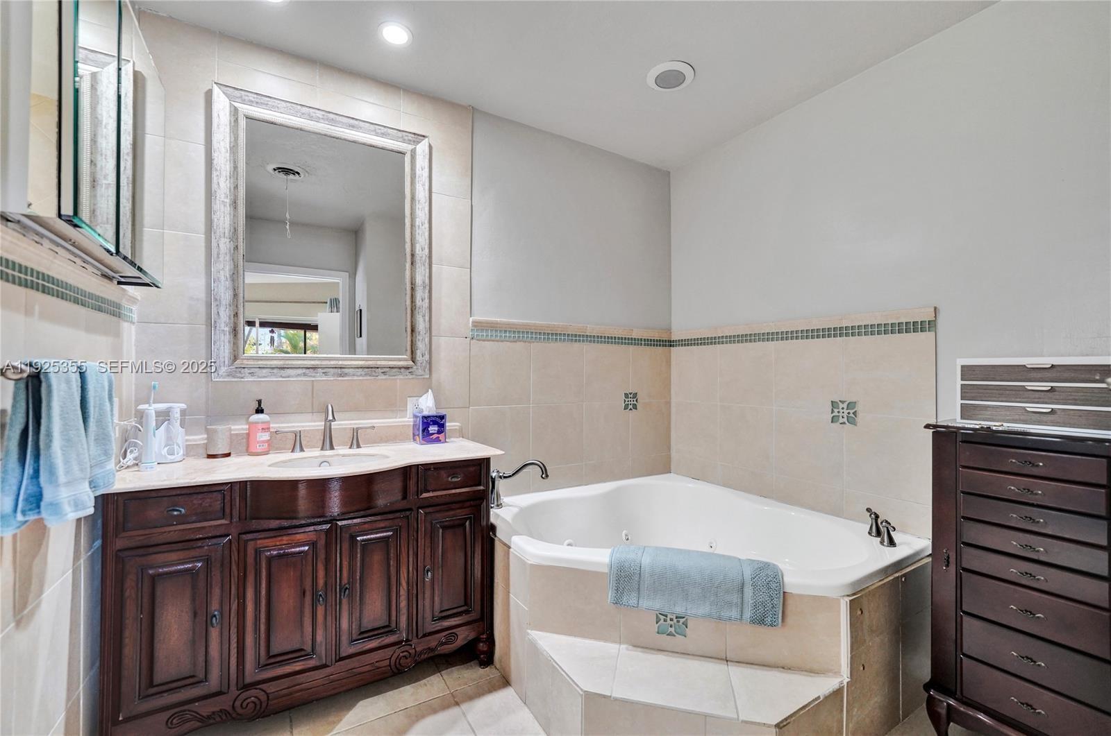 4060 Northeast 26th Avenue Lighthouse Point, FL 33064 - Photo 16 of 34 a bathroom with a sink and a mirror