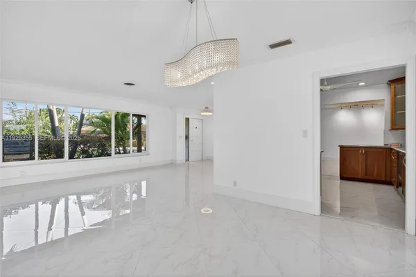 a view of empty room with wooden floor and ceiling fan