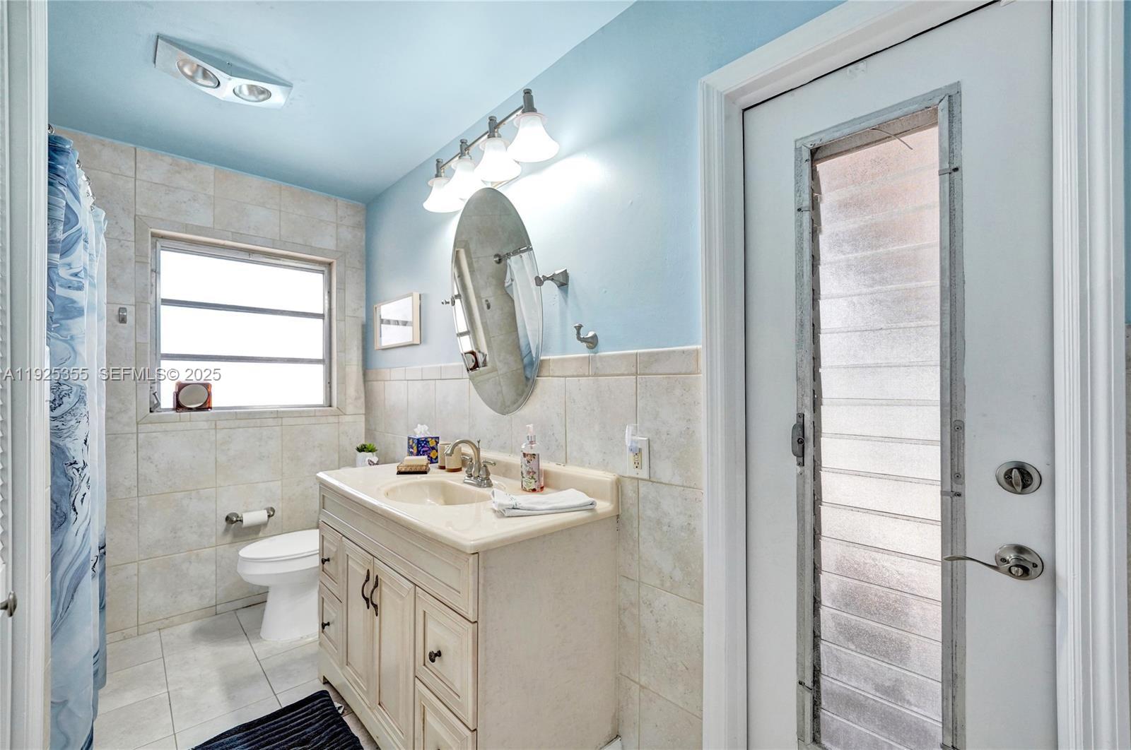 4060 Northeast 26th Avenue Lighthouse Point, FL 33064 - Photo 24 of 34 a bathroom with a double vanity sink toilet and shower