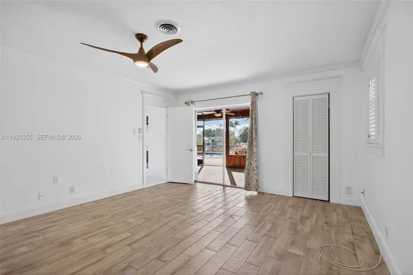 a view of empty room with wooden floor