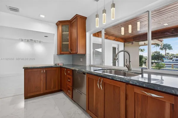 a kitchen with stainless steel appliances granite countertop wooden cabinets and a stove top oven